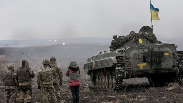 Ukrainian soldiers stay next to an IFV